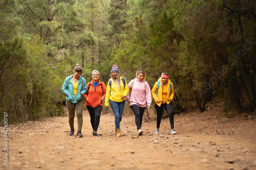 Group of women with different ages and ethnicities having fun walking in the woods - Adventure and travel people concept