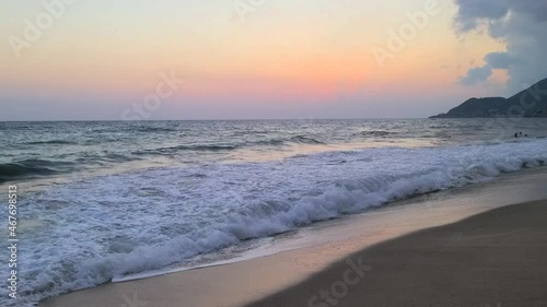 Big sea waves on a sandy beach at sunset. 
