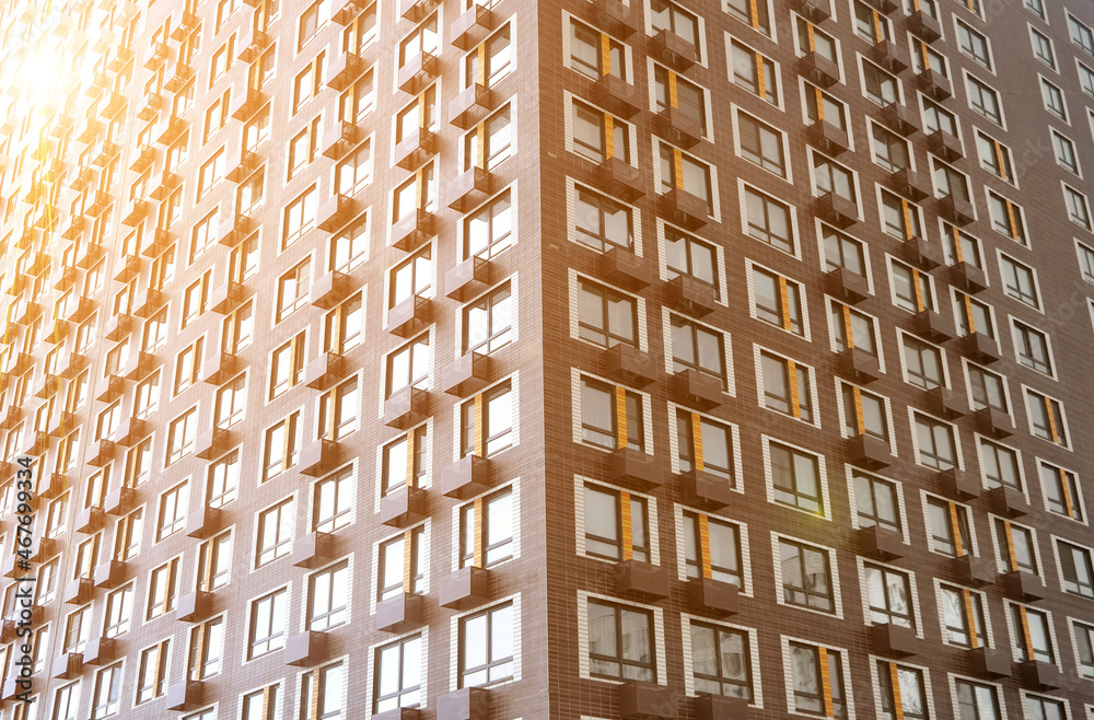 The corner of the front side of a new multi-storey residential building with windows and compartments for outdoor units of split systems. The corner of the front side of a new multi-storey residential building with windows and compartments for outdoor units of split systems.