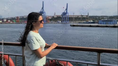 A woman in sunglasses rides a boat on the sea and looks at the water. A woman enjoys a boat ride.