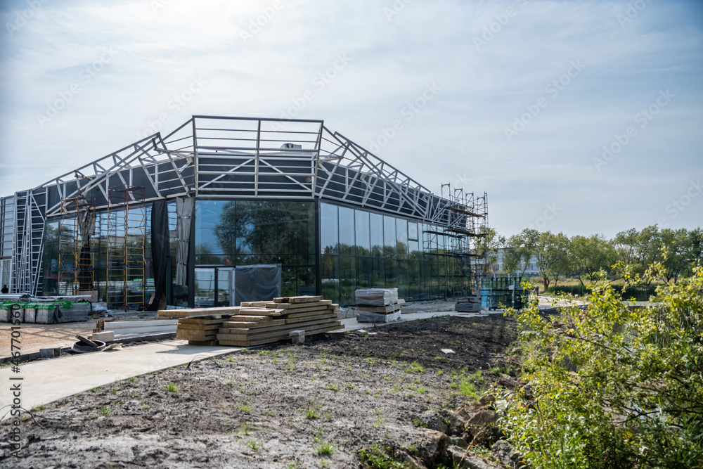 Construction in progress of a building or trade pavilion with glass walls, large windows