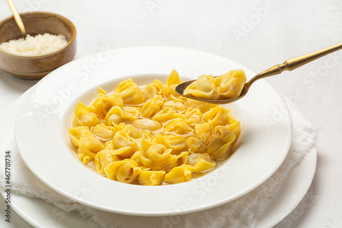 Eating tortellini italian pasta stuffed with a mix of meat, parmigiano cheese and served in capon broth. Close-up.