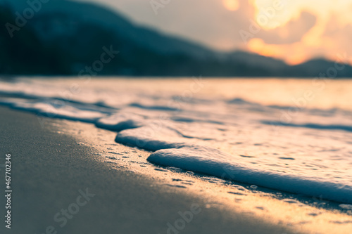 Sea surf on a sandy beach against the backdrop of a colorful sunset