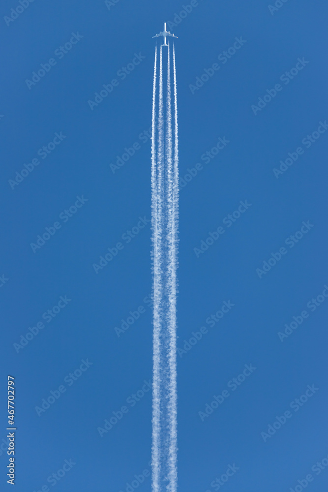engine exhaust contrails behind an four-engined commercial aircraft flying at high altitude engine exhaust contrails behind an four-engined commercial aircraft flying at high altitude