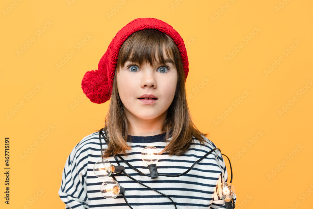 cute smiling girl in a santa hat on isolated yellow background with space for text christmas concept. High quality photo