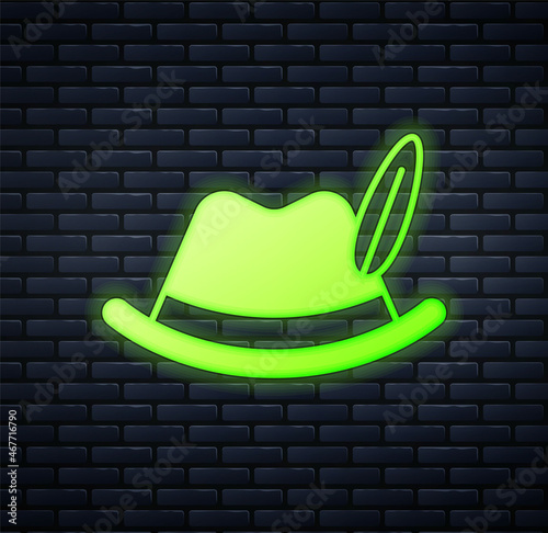 Glowing neon Oktoberfest hat icon isolated on brick wall background. Hunter hat with feather. German hat. Vector