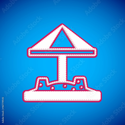 White Sandbox for kids with sand and umbrella icon isolated on blue background. Vector
