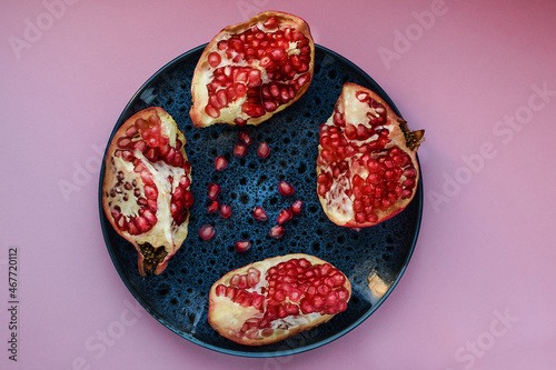 Wallpaper Mural Ripe pomegranate fruits on a dark plate, on a colored background. Healthy eating. Top view. Torontodigital.ca