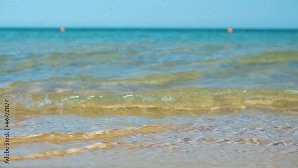Seascape with surface of blue sea water with small ripple waves crashing on yellow sandy beach. Travel and vacations concept Seascape with surface of blue sea water with small ripple waves crashing on yellow sandy beach. Travel and vacations concept
