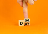 Deal of the day symbol. Businessman turns a wooden cube and changes the word 'day' to 'deal'. Beautiful orange background. Deal of the day and business concept. Copy space.