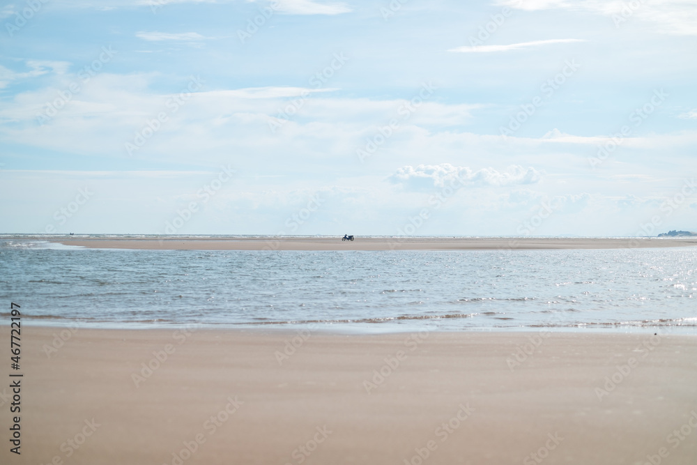 Scenic view of the white sand beach. Motorbike stands on the sand. Sandy island at low tide. High quality photo Scenic view of the white sand beach. Motorbike stands on the sand. Sandy island at low tide. High quality photo