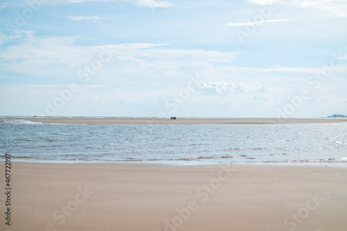 Scenic view of the white sand beach. Motorbike stands on the sand. Sandy island at low tide. High quality photo photo