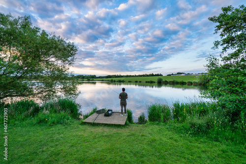 Man fishing at the lake during sunset