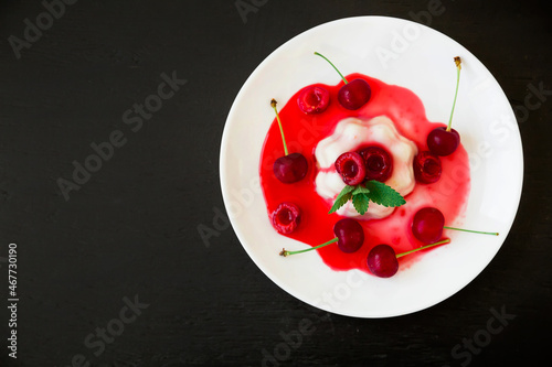 Coconut jelly with summer berries. Panna cotta with sweet cherry in plate.