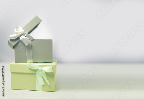 Pastel green and gray gift boxes standing over each other with white background,with copy space.
