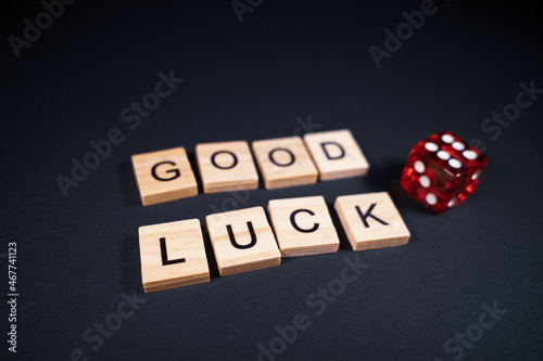 words  Good Luck  were placed with wooden letters and next to them is a red playing dice