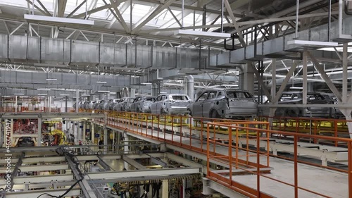 movement of car bodies on a conveyor belt in a paint shop, cast aluminum frames in a modern factory