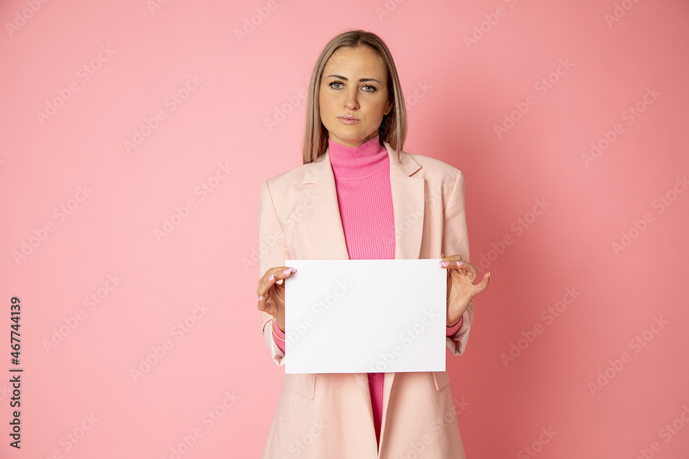 Portrait of attractive young woman holding blank of paper A4 for sign on pink background. businesswoman is wearing pink jacket. Top manager, female blog Portrait of attractive young woman holding blank of paper A4 for sign on pink background. businesswoman is wearing pink jacket. Top manager, female blog