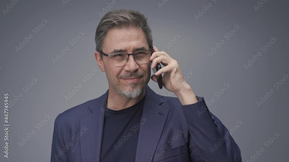 Business portrait - businessman smiling talking on phone. Mature age, middle age, mid adult man in 50s with gray hair and happy confident smile. Copy space. Business portrait - businessman smiling talking on phone. Mature age, middle age, mid adult man in 50s with gray hair and happy confident smile. Copy space.