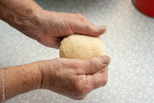 Dough in hands of a elderly woman