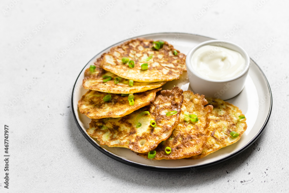 Zucchini pancakes with yogurt sauce. Space for text. Zucchini pancakes with yogurt sauce. Space for text.