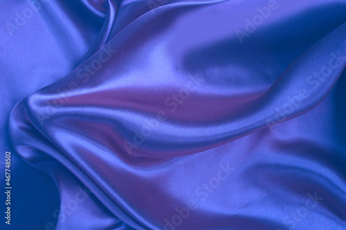 Blue satin background. Silk fabric with pleats. Satin, silk or satin create a beautiful drapery. Fashionable design.