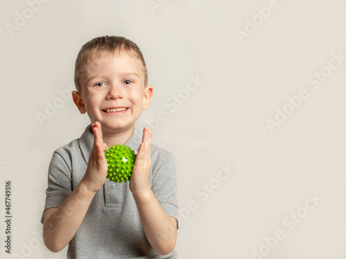 The child performs an exercise with a relief ball the development of tactile sensations. An exercise for of fine motor skills of the hands. Child health concept