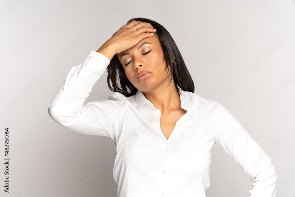 Stressed young african businesswoman suffer from migraine and headache from stress at work. Tired unhappy female touching forehead with closed eyes feeling pain and fatigue from burnout and overwork Stressed young african businesswoman suffer from migraine and headache from stress at work. Tired unhappy female touching forehead with closed eyes feeling pain and fatigue from burnout and overwork