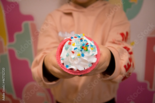 child holding a cupcake made by himself
