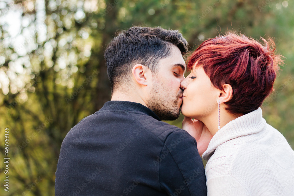 Newlywed couple giving an affectionate kiss outdoors in nature. Newlywed couple giving an affectionate kiss outdoors in nature.