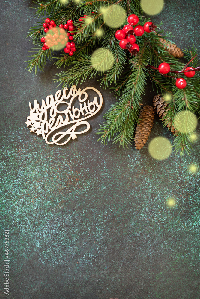 Merry Christmas card. Flat lay with fir tree branch and Christmas decorations with an inscription stating that miracles are real on a dark green stone background. Copy space. Merry Christmas card. Flat lay with fir tree branch and Christmas decorations with an inscription stating that miracles are real on a dark green stone background. Copy space.
