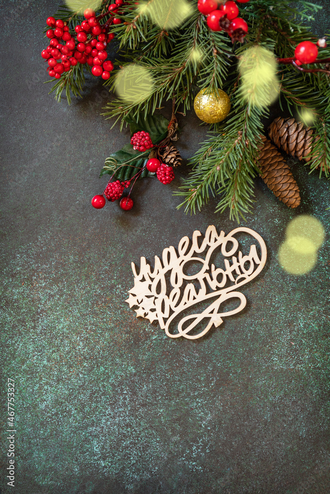 Merry Christmas card. Flat lay with fir tree branch and Christmas decorations with an inscription stating that miracles are real on a dark green stone background. Copy space. Merry Christmas card. Flat lay with fir tree branch and Christmas decorations with an inscription stating that miracles are real on a dark green stone background. Copy space.
