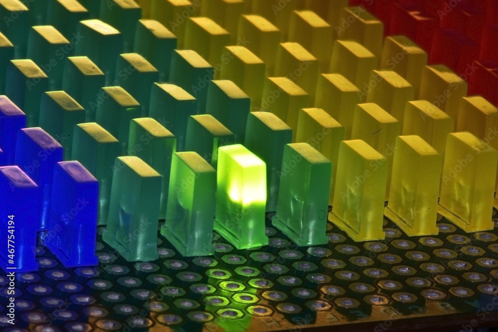 Obraz premium Even rows of rectangular LEDs with a glowing green LED on a circuit board