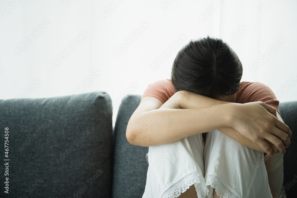 Unhappy Asian young woman having a depressed disorder problem and living alone in living room. Mental health care in young people concept. Unhappy Asian young woman having a depressed disorder problem and living alone in living room. Mental health care in young people concept.