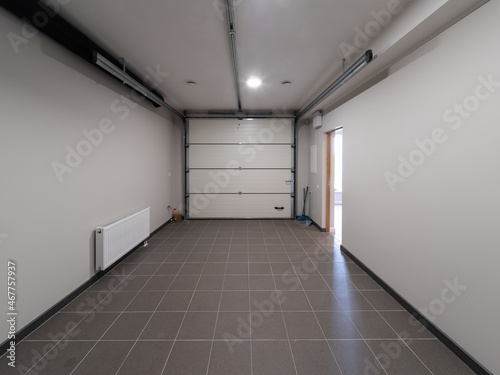 Modern interior of garage of private house. Sectional garage doors