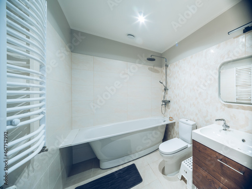 Modern interior of bathroom. White sink  toilet  bath. Tile floor.