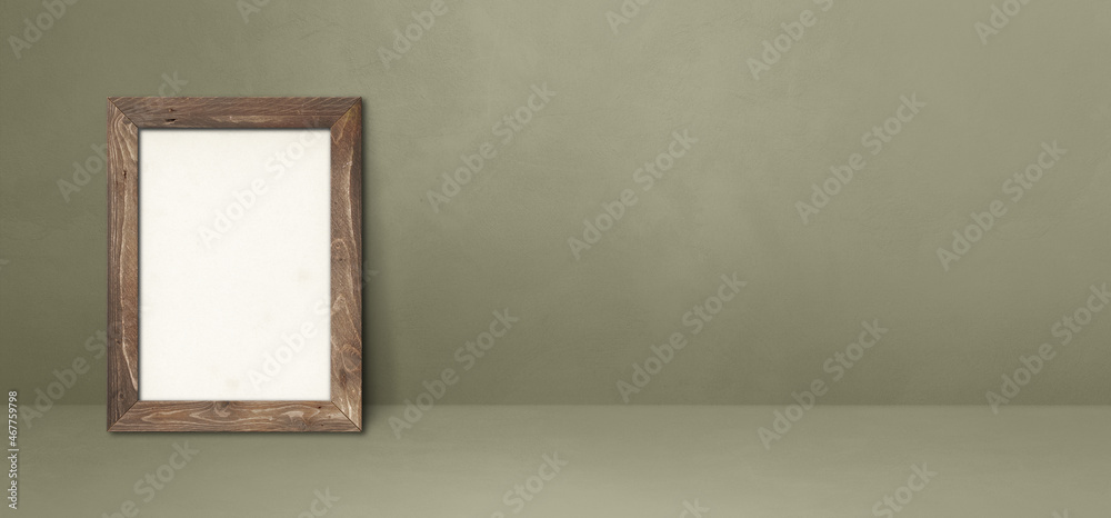 Wooden picture frame leaning on a grey wall. Horizontal banner Wooden picture frame leaning on a grey wall. Horizontal banner