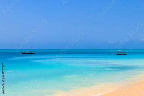 View of tropical sandy Nungwi beach and traditional wooden dhow boats in the Indian ocean on Zanzibar, Tanzania © olyasolodenko
