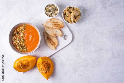 Bowl with vegetarian pumpkin cream soup with toast.