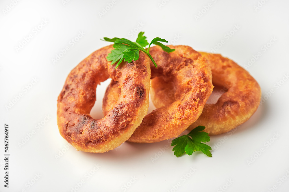 Oven baked or deep-fried breaded calamari rings over white backround