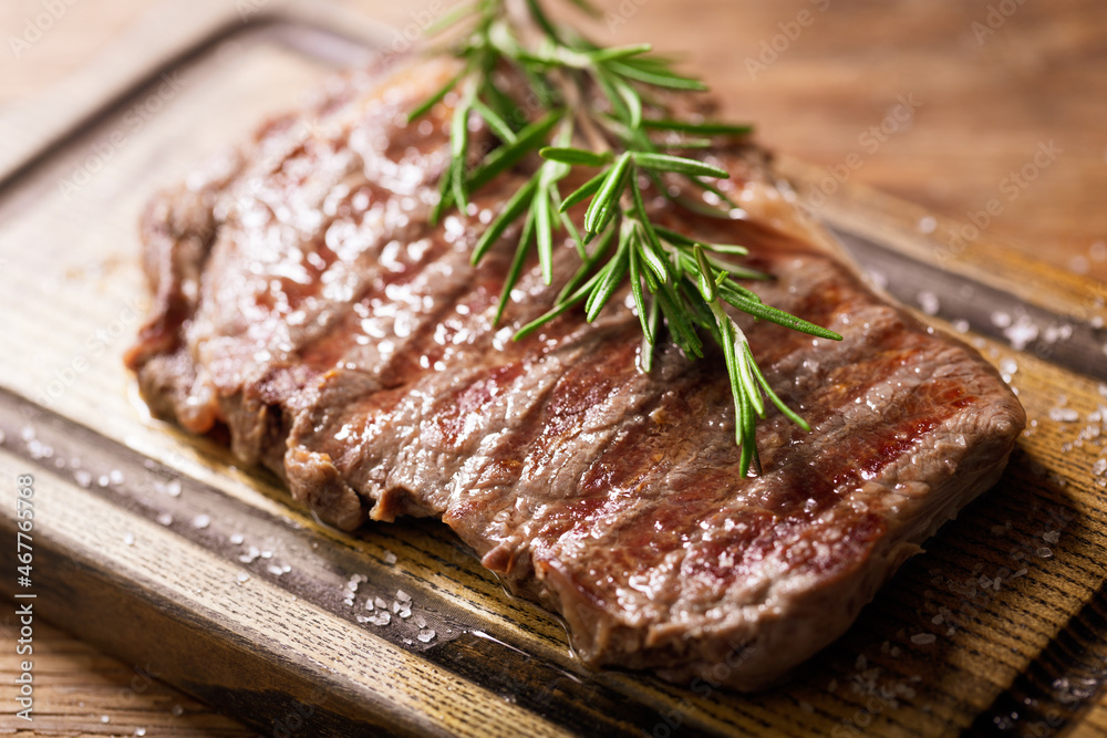 grilled meat with rosemary on a wooden board