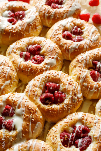 Homemade sweet yeast buns with raspberries and white chocolate, close up view