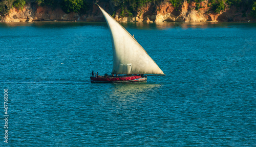 Faluka sailing boat leaving Dar Es Salaam Harbour in direction open Ocean, Tanzania photo