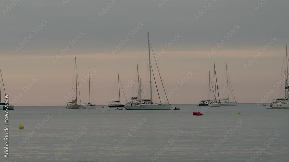 Sailboats during a sunset sailing in the sea Sailboats during a sunset sailing in the sea