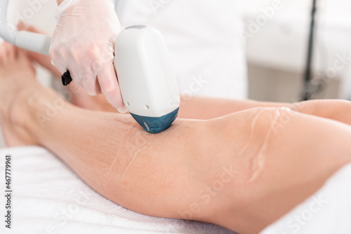 Hair removal on ladies legs. Laser epilation and cosmetology. Cosmetic beauty spa clinic. Cosmetology procedure from a therapist