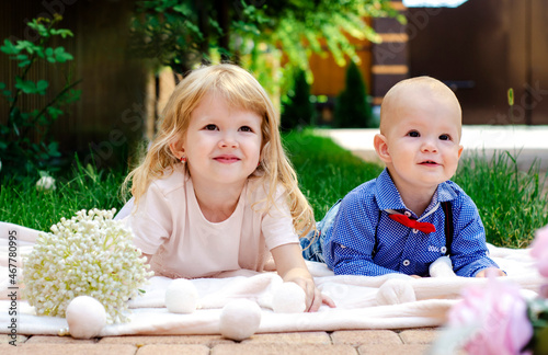 2 children laying in the grass. 'Mom says we need to sit here and smile'