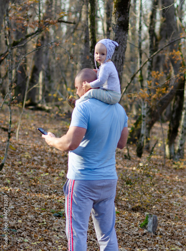 father walks in the autumn forest with his little son