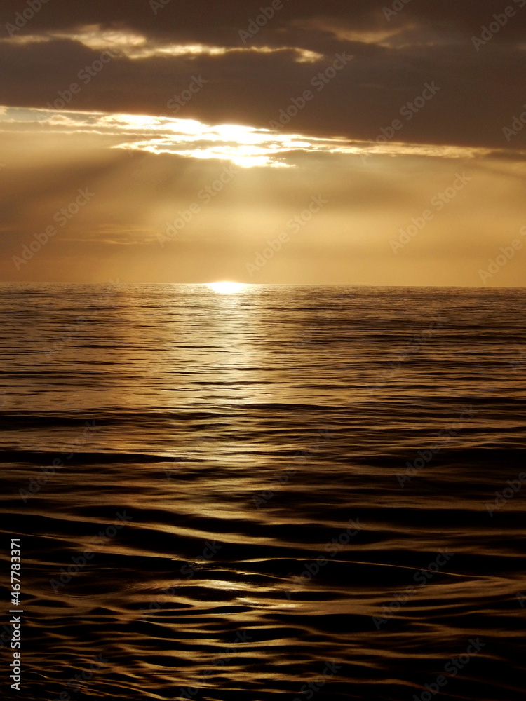 Sunlight reflected on gentle waves in the sea at dusk