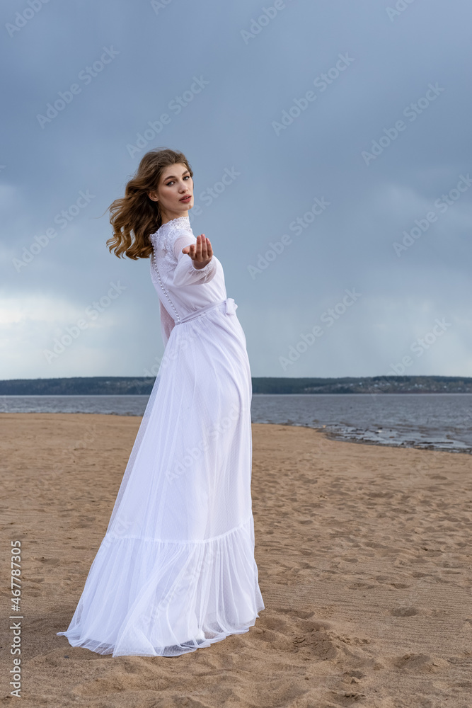 Happy young girl in a white dress on the sandy shore. Thunder Sky Happy young girl in a white dress on the sandy shore. Thunder Sky
