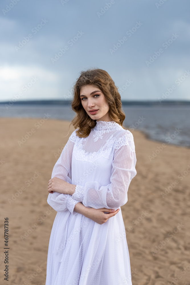 Happy young girl in a white dress on the sandy shore. Thunder Sky Happy young girl in a white dress on the sandy shore. Thunder Sky